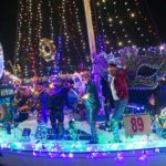 Mardis Gras themed boats parade past excited onlookers on the Kemah Boardwalk during the Yachty Gras Boat Parade.